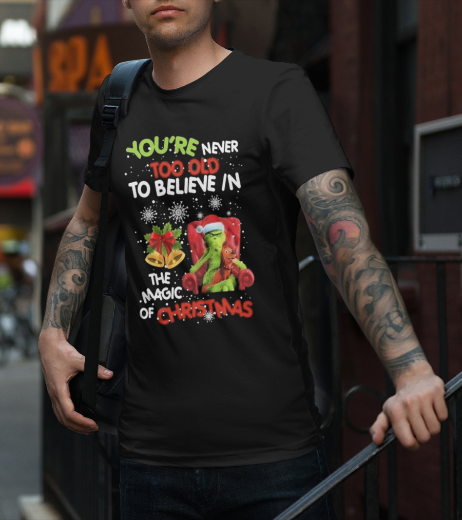 YOU'RE NEVER TOO OLD TO BELIEVE IN THE MAGIC OF CHRISTMAS GRINCH WITH MAX SITTING IN CHAIR SNOWFLAKES HOLIDAY BELLS AND BOW T-Shirt